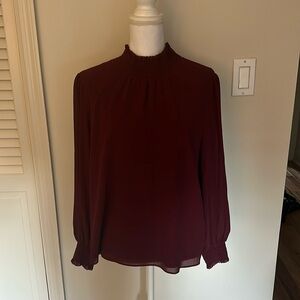 Classic silk like “wrinkled” mock neck blouse with detail at neck and cuff